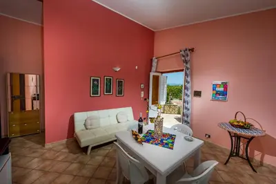 a living room with red walls and a white couch at Villa Oasi del Relax Flavianna in Castellammare del Golfo
