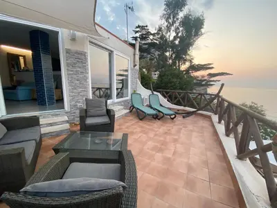 a patio with chairs and a hammock on a house at Mare e cielo in Porticello