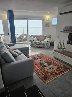 a living room with a couch and a rug at Mare e cielo in Porticello