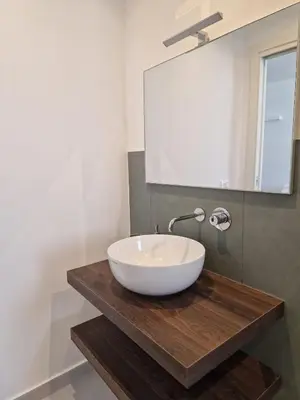 a bathroom with a white bowl sink on a wooden counter at SPRING APARTMENTS in Palermo