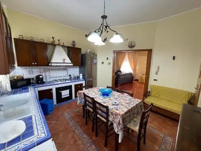 a kitchen and living room with a table and a couch at Casa Michela in Palermo
