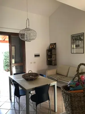 a living room with a table and chairs at Casa al mare a Campofelice di Roccella - Cefalù in Lascari