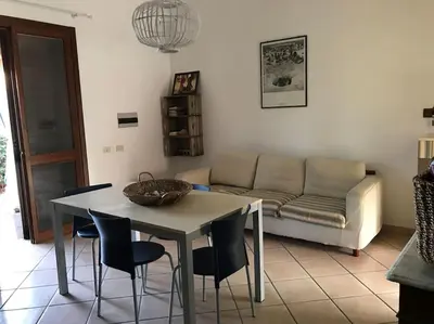 a living room with a table and chairs and a couch at Casa al mare a Campofelice di Roccella - Cefalù in Lascari