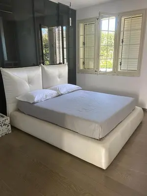 a large white bed in a bedroom with two windows at Villa Rachele con piscina in Balestrate
