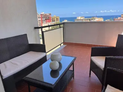 a balcony with two chairs and a table with a view at harriets house in Palermo