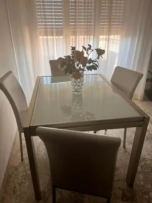 a dining room table with a vase of flowers on it at harriets house in Palermo