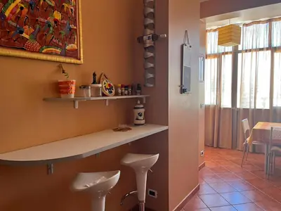 a kitchen with a counter and stools in a room at harriets house in Palermo