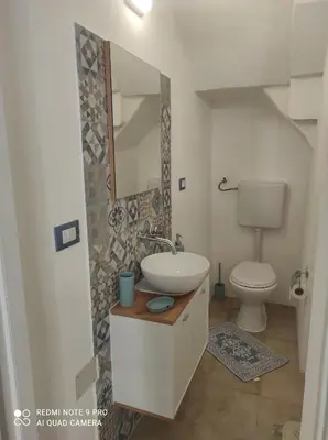 a bathroom with a sink and a toilet at La casetta di Toto' in Isola delle Femmine