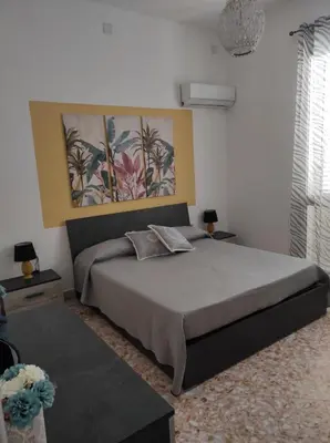 a bedroom with a bed and a painting on the wall at La casetta di Toto' in Isola delle Femmine