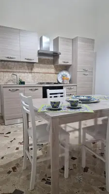 a kitchen with a white table and chairs in a kitchen at CasaVe in Palermo