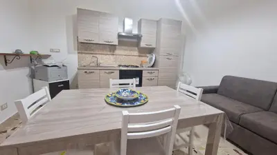 a table and chairs in a kitchen with a couch at CasaVe in Palermo
