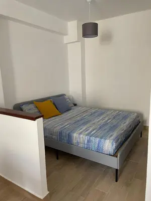 a bedroom with a bed with a yellow pillow at Casa di Leda in Santa Flavia