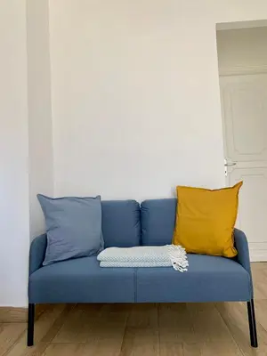 a blue couch with two yellow pillows in a room at Casa di Leda in Santa Flavia
