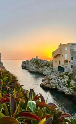 a sunset over a body of water with buildings at Casa di Leda in Santa Flavia