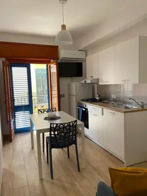 a kitchen with a table and a table and chairs at Casa di Leda 1 in Santa Flavia