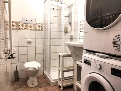 a bathroom with a toilet and a washing machine at Alvarado - Your Home in Sicily in Carini