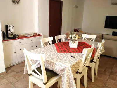 a dining room table and chairs with a vase of flowers on it at Alvarado - Your Home in Sicily in Carini