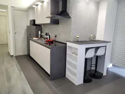 a kitchen with a sink and a counter with stools at SP Rooms in Isola delle Femmine