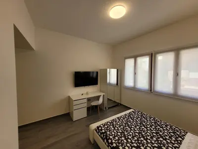 a bedroom with a bed and a desk and a television at SP Rooms in Isola delle Femmine