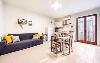 a living room with a blue couch and a kitchen at Lovely Apartment In Trappeto With Wifi in Trappeto
