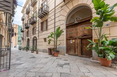an alley with a large wooden door and potted plants at Casa Marettu in Palermo
