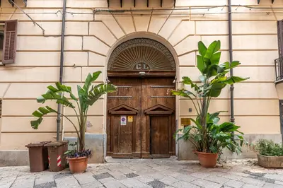 a wooden door in a building with plants in front at Casa Marettu in Palermo