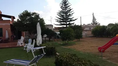 a yard with chairs and a slide and a playground at Villacinisi in Cinisi