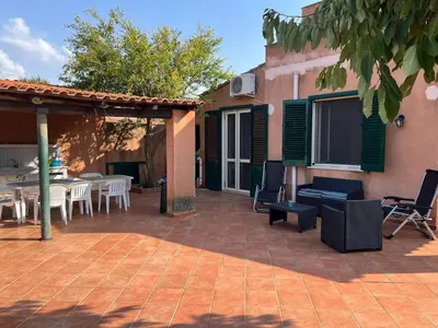 a patio with tables and chairs and a building at Villacinisi in Cinisi