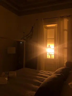 a room with a bed and a door with the light coming in at Casa degli Allori in Palermo