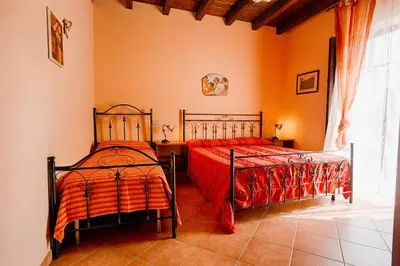two beds in a bedroom with orange walls at GuestHost - Corso Garibaldi - Castellammare Central Flats in Castellammare del Golfo