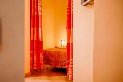 a bedroom with orange and red curtains and a bed at GuestHost - Corso Garibaldi - Castellammare Central Flats in Castellammare del Golfo