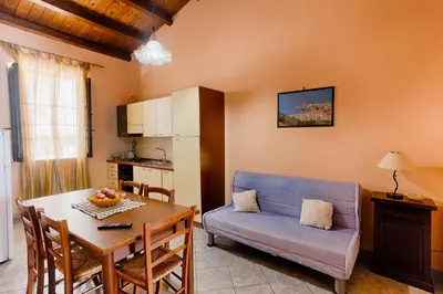 a living room with a table and a blue couch at GuestHost - Corso Garibaldi - Castellammare Central Flats in Castellammare del Golfo