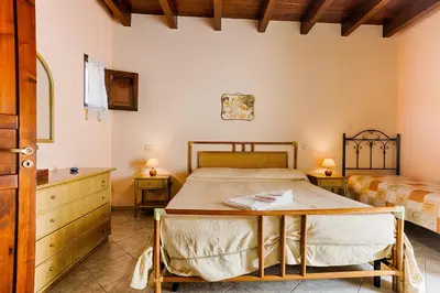 a bedroom with a bed and two twin beds at GuestHost - Corso Garibaldi - Castellammare Central Flats in Castellammare del Golfo