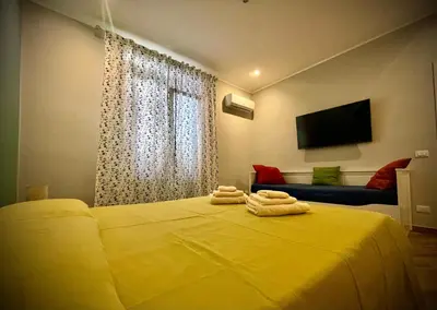 a yellow bed with two towels on top of it at Casa Batù alle porte del Capo in Palermo