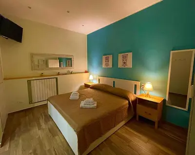 a bedroom with a bed and two lamps and a mirror at Casa Batù alle porte del Capo in Palermo