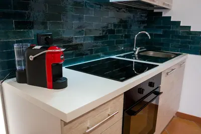 a kitchen with a counter with a sink and a stove at Le Case di Romeo in Palermo
