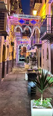 a building with lights and a courtyard with a plant at Le Case di Romeo in Palermo