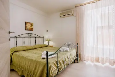 a bedroom with a bed and a large window at GuestHost - Castellammare Stella Apartments in Castellammare del Golfo