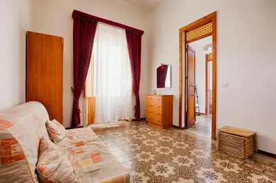 a bedroom with a bed and a dresser and a mirror at GuestHost - Castellammare Stella Apartments in Castellammare del Golfo