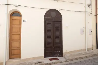a wooden door on the side of a building at GuestHost - Castellammare Stella Apartments in Castellammare del Golfo