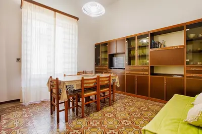 a dining room with a table and some chairs at GuestHost - Castellammare Stella Apartments in Castellammare del Golfo