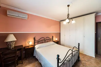 a bedroom with a bed and a dresser and a lamp at Bed And Breakfast Marina d'Aspra in Bagheria