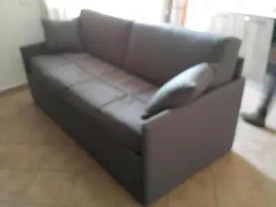a brown couch with a pillow on top of it at Bed And Breakfast Marina d'Aspra in Bagheria