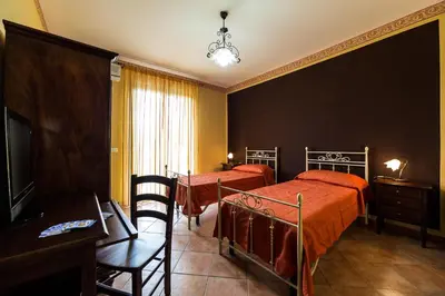 a hotel room with two beds and a television at Bed And Breakfast Marina d'Aspra in Bagheria