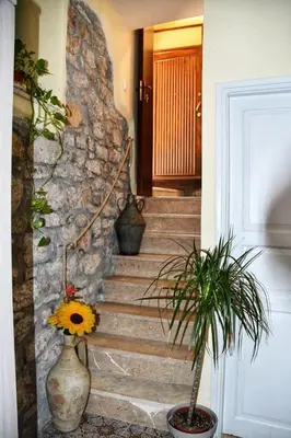 a hallway with a staircase with a stone wall at L' Arco Antico in Caccamo