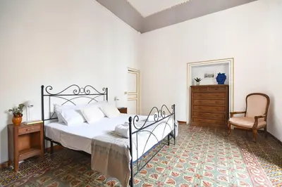 a bedroom with a bed and a chair and a dresser at iFlat Casa Ponticello Kemonia in Palermo