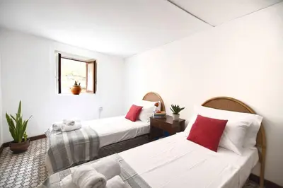 two beds in a room with white walls and red pillows at iFlat Casa Ponticello Kemonia in Palermo