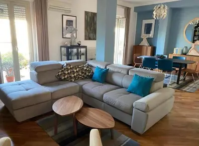 a living room with a large couch and blue walls at MONTE PELLEGRINO HOUSE AND TERRACE in Palermo