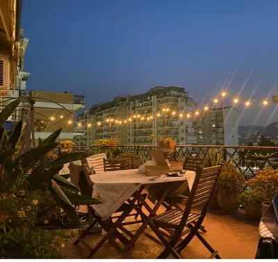 a table and chairs on a balcony with lights at MONTE PELLEGRINO HOUSE AND TERRACE in Palermo
