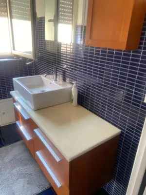 a bathroom with a sink and blue tiled walls at MONTE PELLEGRINO HOUSE AND TERRACE in Palermo